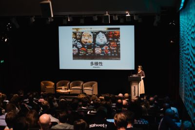 Margaret Lee is speaking (for the first time) at the Leading Design conference in 2016. Sheâ€™s standing behind a lectern; a slide is projected on the screen next to her on the stage