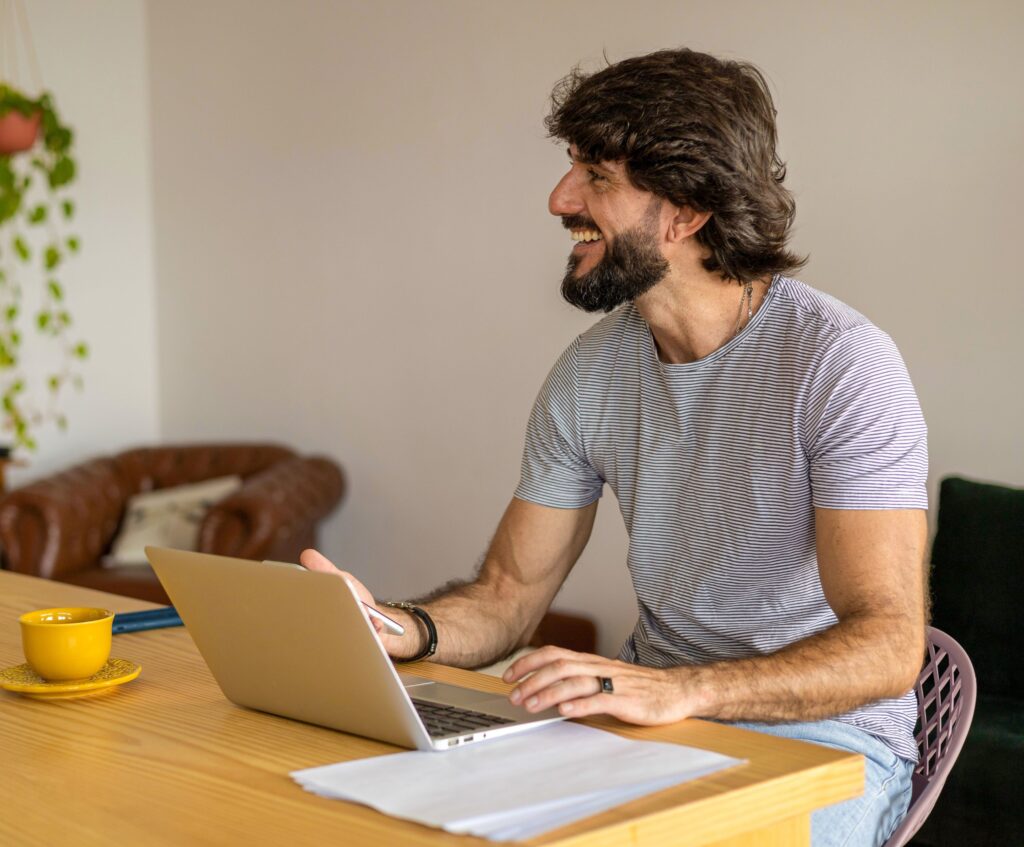 a man sitting at a table using a laptop